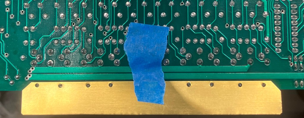 IMage of the bottom side of the RC-96 showing the brass strip with match-drilled holes aligned to the connector pins.